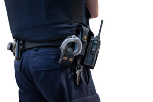 Police officer, with gun belt, handcuffs phone and pepper-spray. Isolated on white background