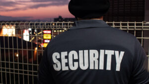 A rear view of a security guard looking down the street and sunset.